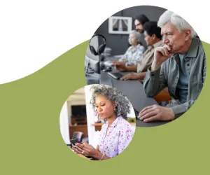 An older woman interacts with a tablet, while an older man is seated in a chair, working on his computer.